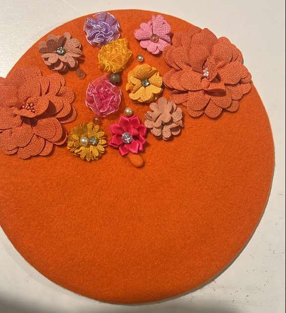 Orange felt beret decorated with multicolor fabric flowers and pearl accents