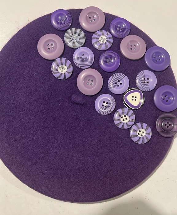 Deep purple felt beret decorated with assorted purple buttons