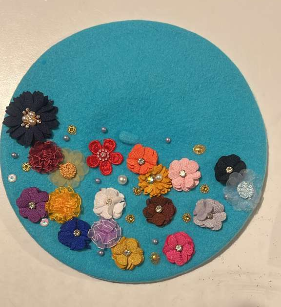 Turquoise felt beret decorated with multicolor fabric flowers with rhinestone centers and scattered pearl beads